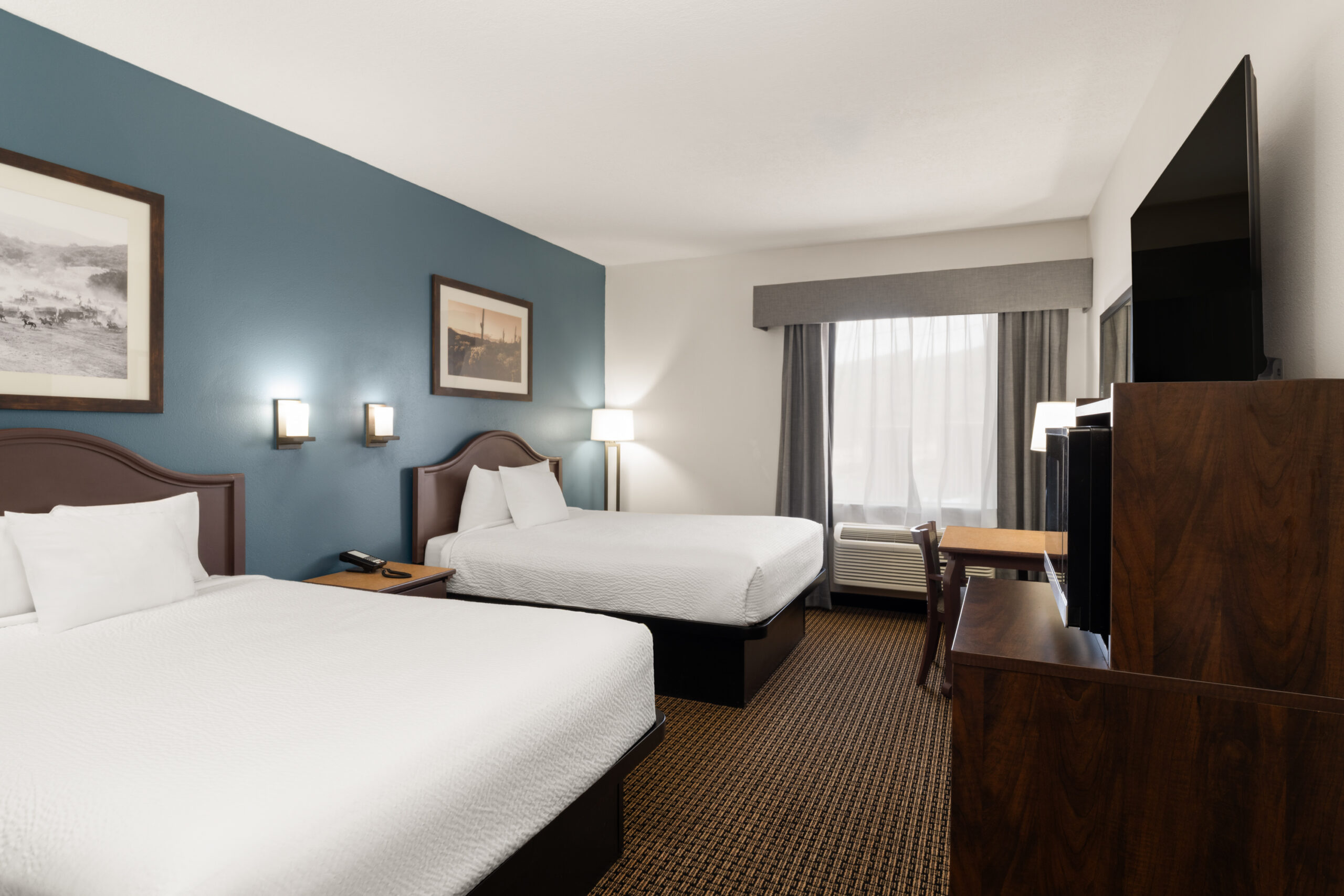 Two queen guest room with bright bedding at Tombstone Grand Hotel