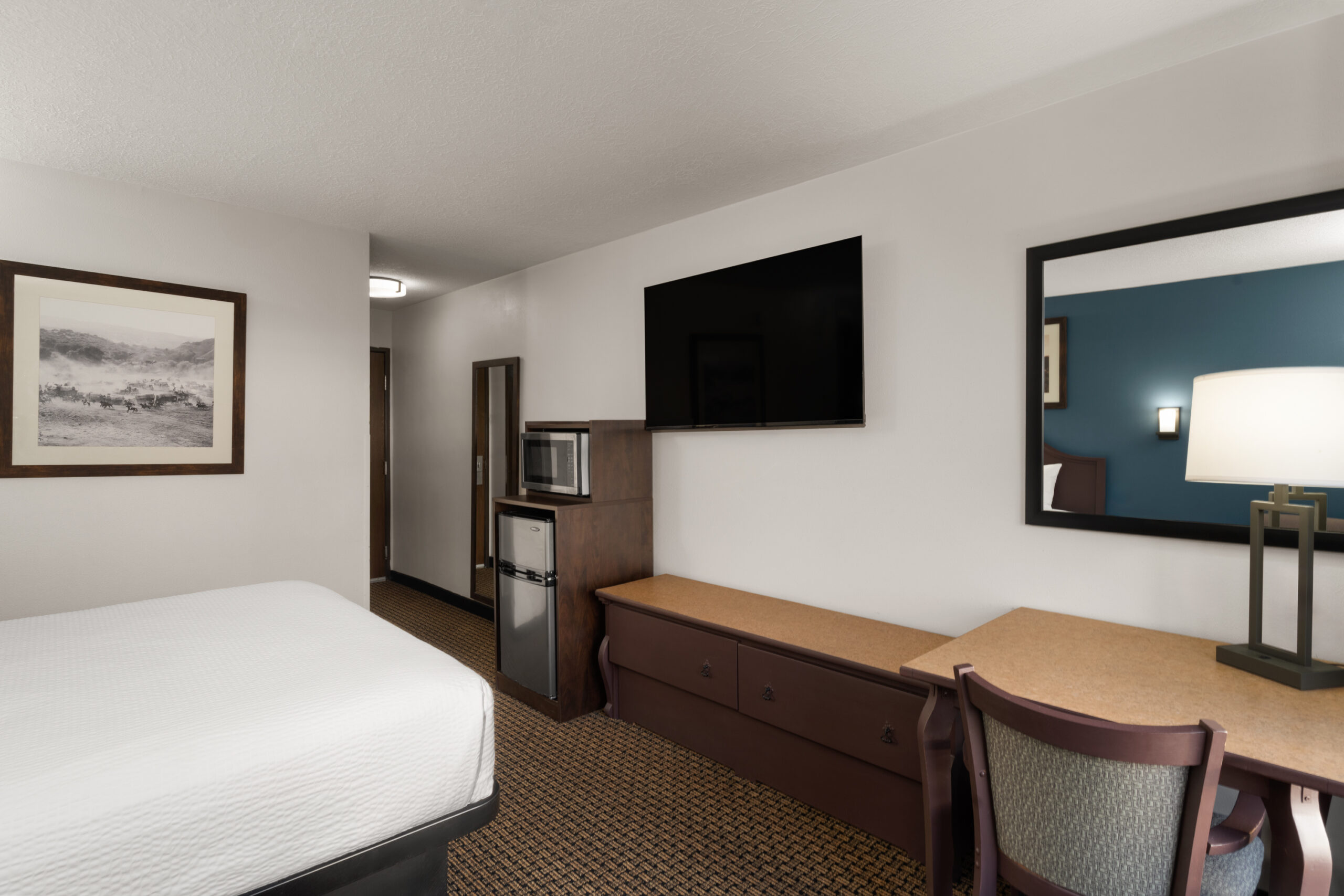 King suite-style guest room with seating area at Tombstone Grand Hotel