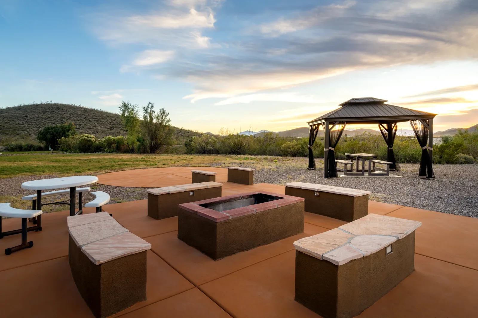 Outdoor fire pit seating and covered picnic area overlooking the desert
